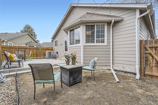 rear view of property featuring a gate, central air condition unit, a patio, and fence