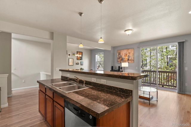 bar area with stainless steel dishwasher, a sink, light wood-style flooring, baseboards, and hanging light fixtures