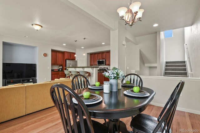 dining space featuring light wood finished floors, a chandelier, stairway, and recessed lighting
