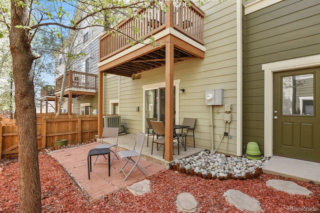 back of property featuring a balcony, fence, and a patio