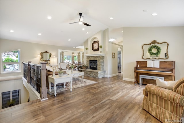 40 Wuthering Heights Dr, Colorado Springs, CO 80921 - living room with lofted ceiling, ceiling fan, a stone fireplace, wood finished floors, and arched walkways
