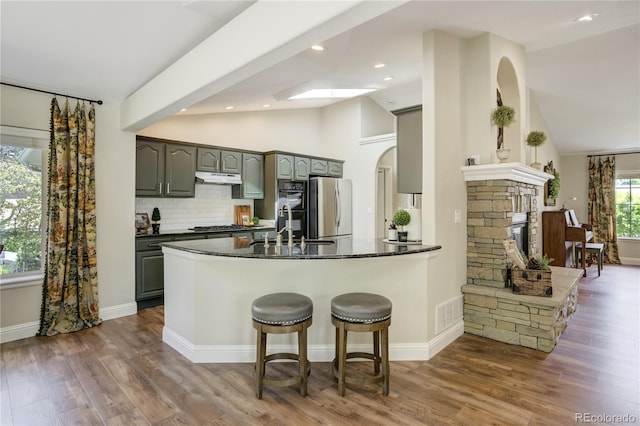 40 Wuthering Heights Dr, Colorado Springs, CO 80921 - kitchen featuring freestanding refrigerator, a sink, a peninsula, arched walkways, and gray cabinets