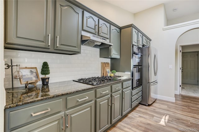 40 Wuthering Heights Dr, Colorado Springs, CO 80921 - kitchen with freestanding refrigerator, gas cooktop, under cabinet range hood, light wood-style flooring, and decorative backsplash