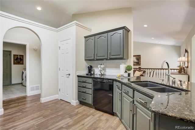 40 Wuthering Heights Dr, Colorado Springs, CO 80921 - kitchen with dishwasher, a sink, washer / clothes dryer, dark stone counters, and arched walkways