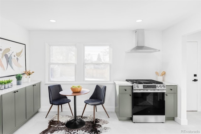 kitchen featuring breakfast area, wall chimney exhaust hood, gray cabinets, and stainless steel gas range