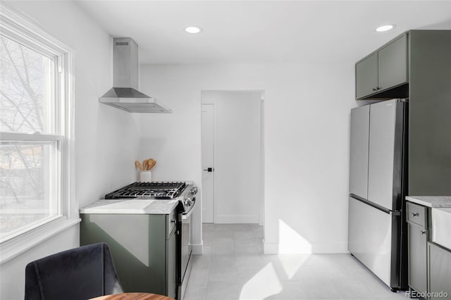 kitchen with gray cabinets, light tile patterned flooring, appliances with stainless steel finishes, and wall chimney exhaust hood