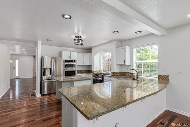 5403 Odessa St, Denver, CO 80249 - kitchen with stainless steel appliances, a sink, a kitchen island, a peninsula, and baseboards