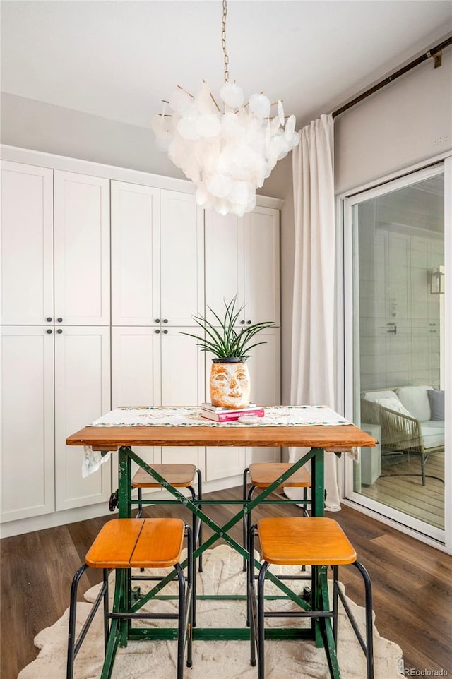 dining space featuring dark hardwood / wood-style floors and an inviting chandelier