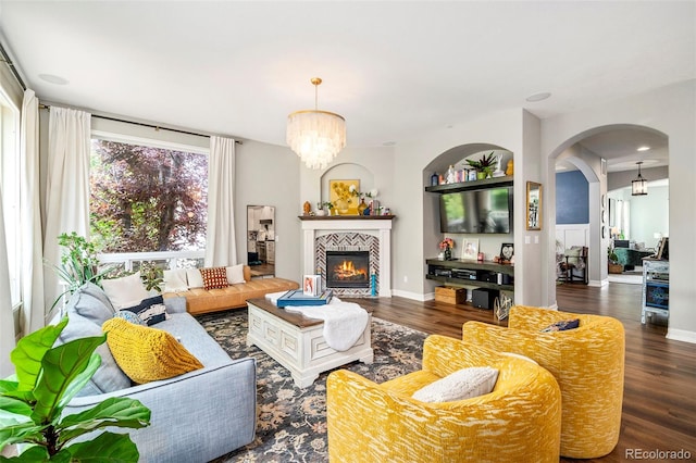 living room with a fireplace, a chandelier, and dark hardwood / wood-style floors