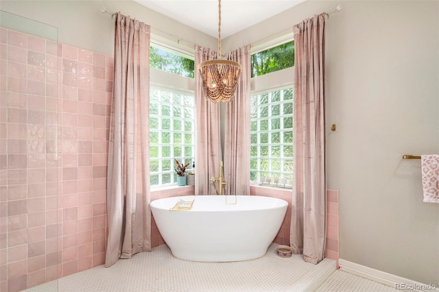 bathroom with tile walls, tile patterned flooring, and a healthy amount of sunlight