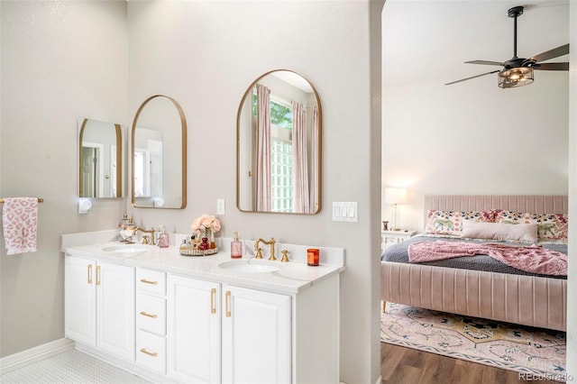 bathroom with wood-type flooring, dual bowl vanity, and ceiling fan