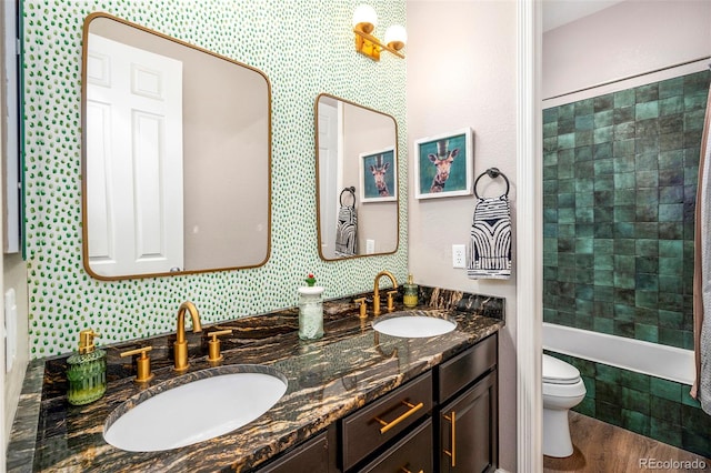 bathroom featuring hardwood / wood-style floors, dual vanity, and toilet