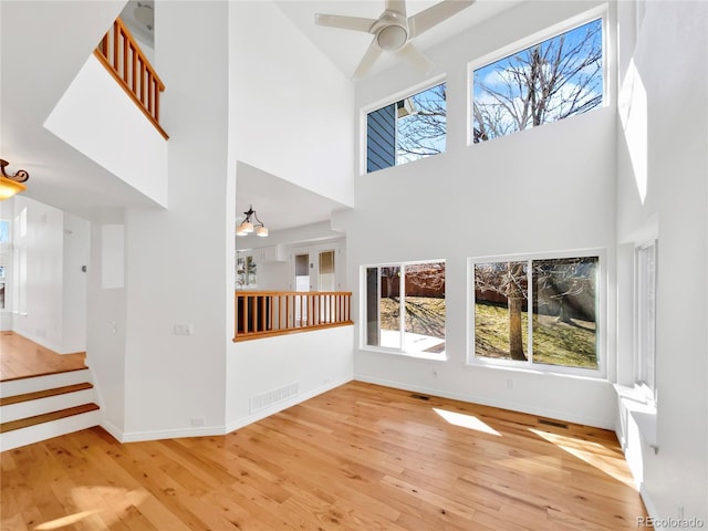 unfurnished living room featuring baseboards, visible vents, and hardwood / wood-style floors