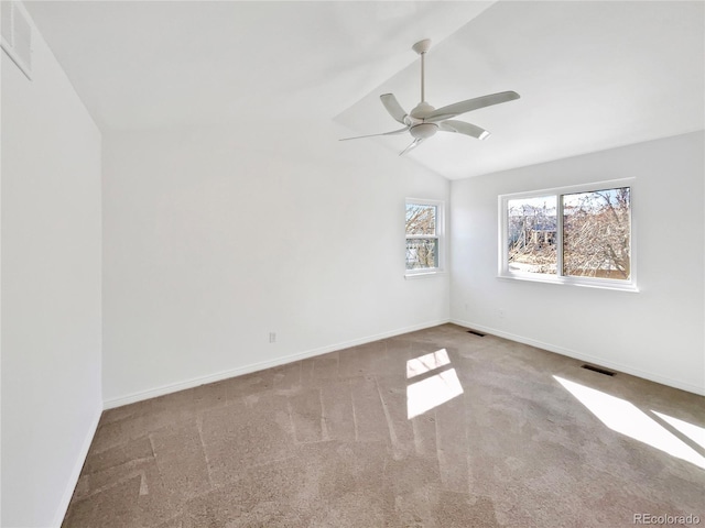 empty room with ceiling fan, carpet floors, visible vents, baseboards, and vaulted ceiling