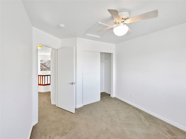 unfurnished bedroom with light carpet, a closet, a ceiling fan, and baseboards