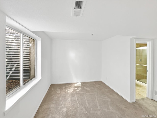 carpeted empty room with visible vents and baseboards