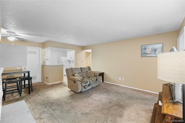 living room featuring ceiling fan, light colored carpet, and a textured ceiling