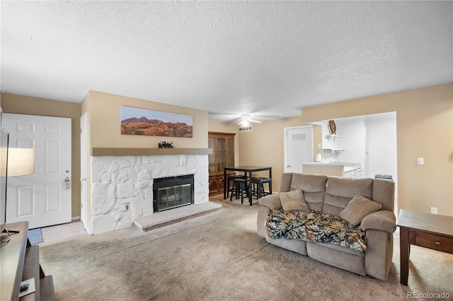 living room featuring carpet flooring, a textured ceiling, and a fireplace