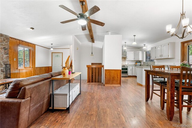 25531 Mosier Cir, Conifer, CO 80433 - living area featuring wood walls, ceiling fan, light wood-style flooring, wainscoting, and vaulted ceiling