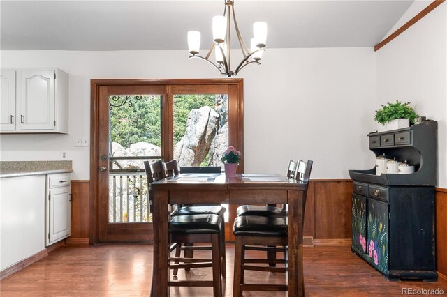 25531 Mosier Cir, Conifer, CO 80433 - dining area featuring wainscoting, a chandelier, wood finished floors, and wooden walls