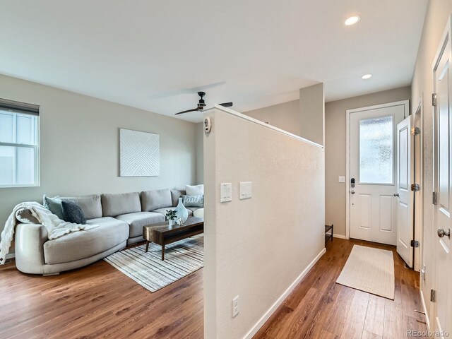 living room featuring a ceiling fan, recessed lighting, wood finished floors, and baseboards