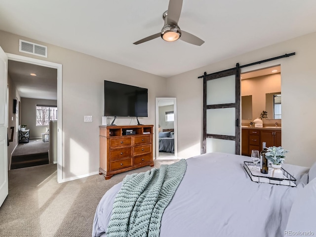 bedroom featuring a ceiling fan, carpet, visible vents, baseboards, and a barn door