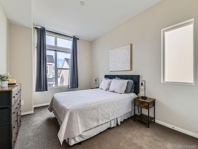 bedroom featuring dark colored carpet and baseboards