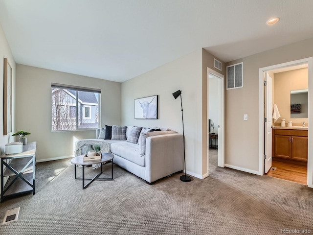 living area with visible vents, baseboards, and carpet flooring