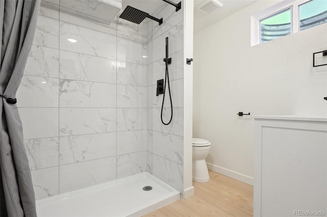 full bath featuring visible vents, wood finished floors, toilet, baseboards, and a shower stall