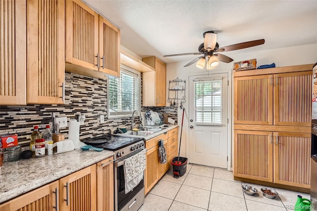 6736 Grove St, Denver, CO 80221 - kitchen with electric range, decorative backsplash, ceiling fan, light tile patterned floors, and light brown cabinetry