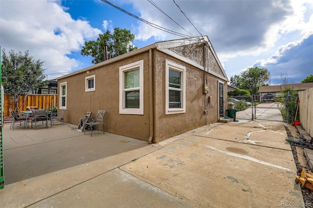 6736 Grove St, Denver, CO 80221 - view of side of property featuring stucco siding, a patio area, and a gate
