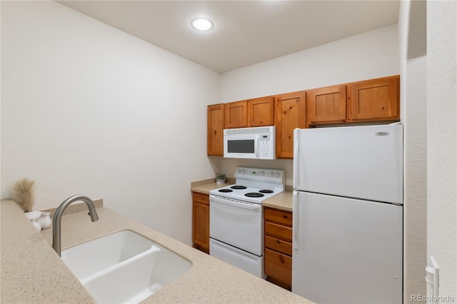 kitchen with brown cabinetry, white appliances, and a sink