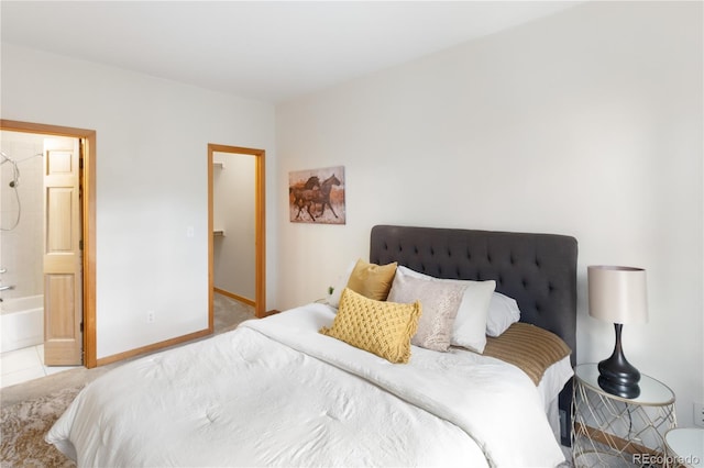 bedroom with ensuite bath and baseboards