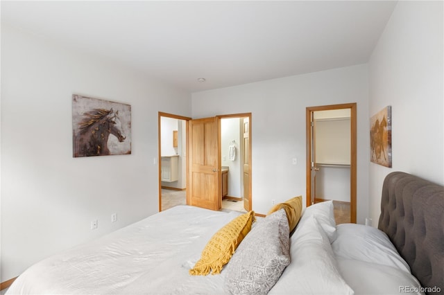 bedroom featuring a walk in closet, a closet, and ensuite bathroom