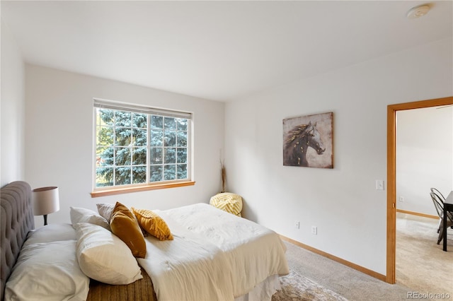 bedroom with light colored carpet and baseboards