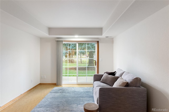 living area featuring visible vents, light wood finished floors, and baseboards