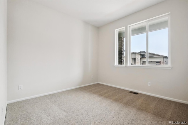 carpeted spare room with baseboards