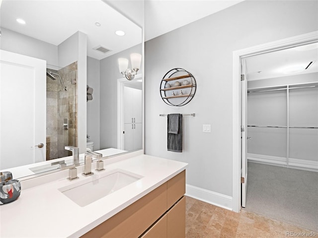 bathroom with vanity, toilet, and a tile shower