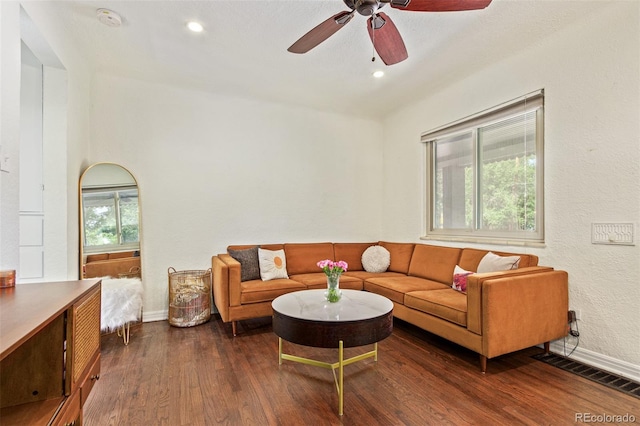 living room with ceiling fan and dark wood-type flooring