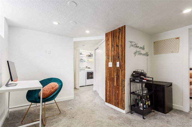 home office featuring washer / clothes dryer, a textured ceiling, and light colored carpet