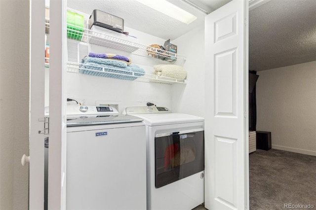 clothes washing area with dark colored carpet, washing machine and dryer, and a textured ceiling