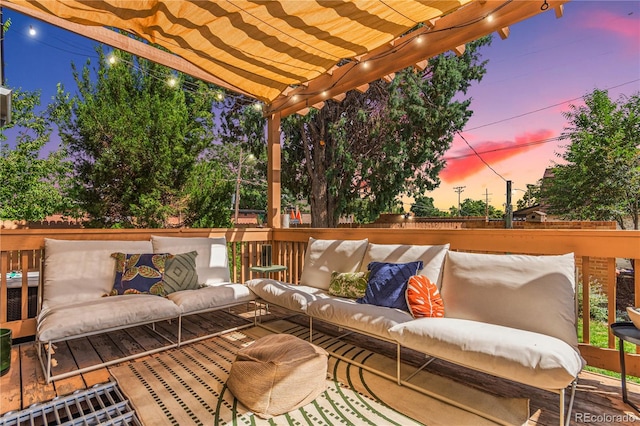 deck at dusk with a pergola and an outdoor hangout area