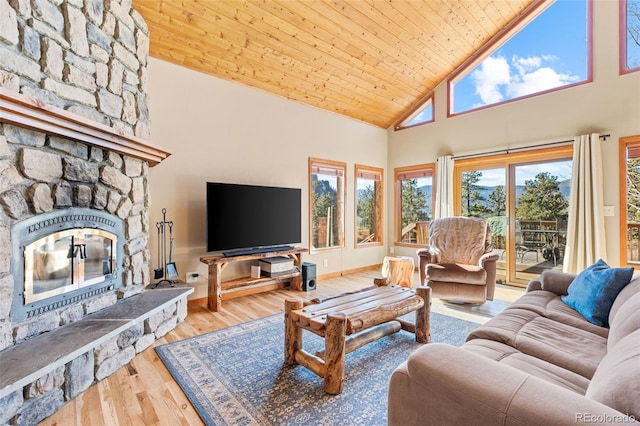 living room with high vaulted ceiling, wood finished floors, a stone fireplace, wooden ceiling, and baseboards