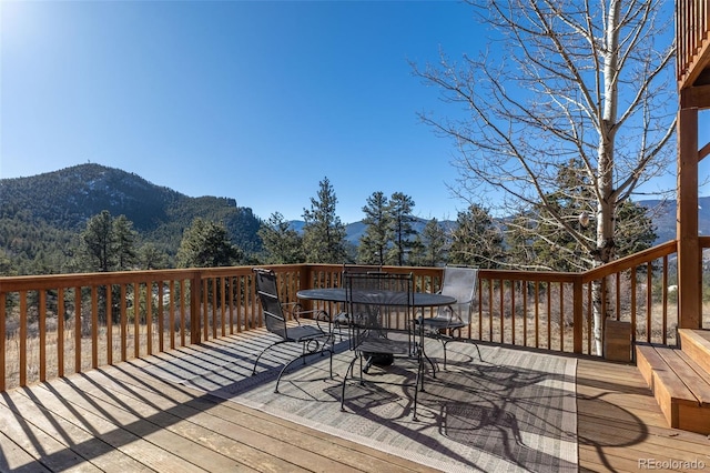 wooden deck featuring outdoor dining area and a mountain view