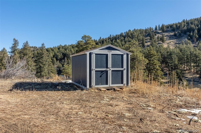 view of shed featuring a wooded view