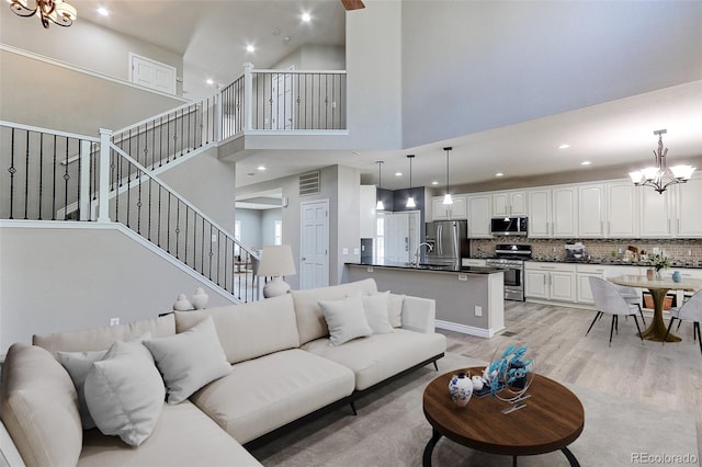 2901 Madison Ln, Broomfield, CO 80023 - living area with a chandelier, a towering ceiling, light wood-style flooring, recessed lighting, and stairway