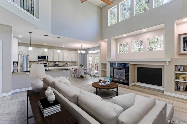 2901 Madison Ln, Broomfield, CO 80023 - living area featuring a towering ceiling, a tile fireplace, light wood finished floors, healthy amount of natural light, and recessed lighting