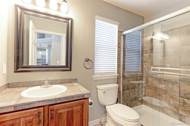 2901 Madison Ln, Broomfield, CO 80023 - full bath featuring vanity, toilet, a tile shower, and a textured wall
