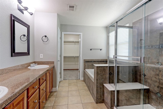 2901 Madison Ln, Broomfield, CO 80023 - full bath featuring a garden tub, a shower stall, double vanity, tile patterned floors, and a walk in closet