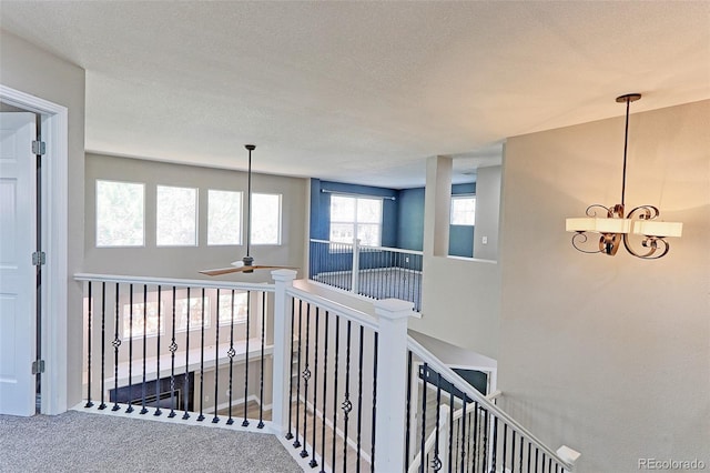 2901 Madison Ln, Broomfield, CO 80023 - hallway featuring carpet, a chandelier, a textured ceiling, and an upstairs landing